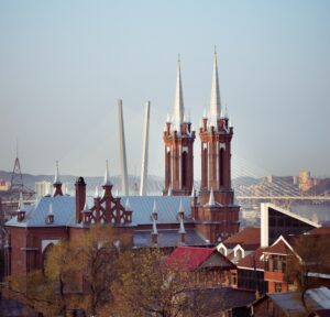 A view of Most Holy Mother of God Catholic Church in Vladivostok, showing the new roof and the steeples that were added to the building. In the background is a section of one of the city's new cable-stayed bridges.